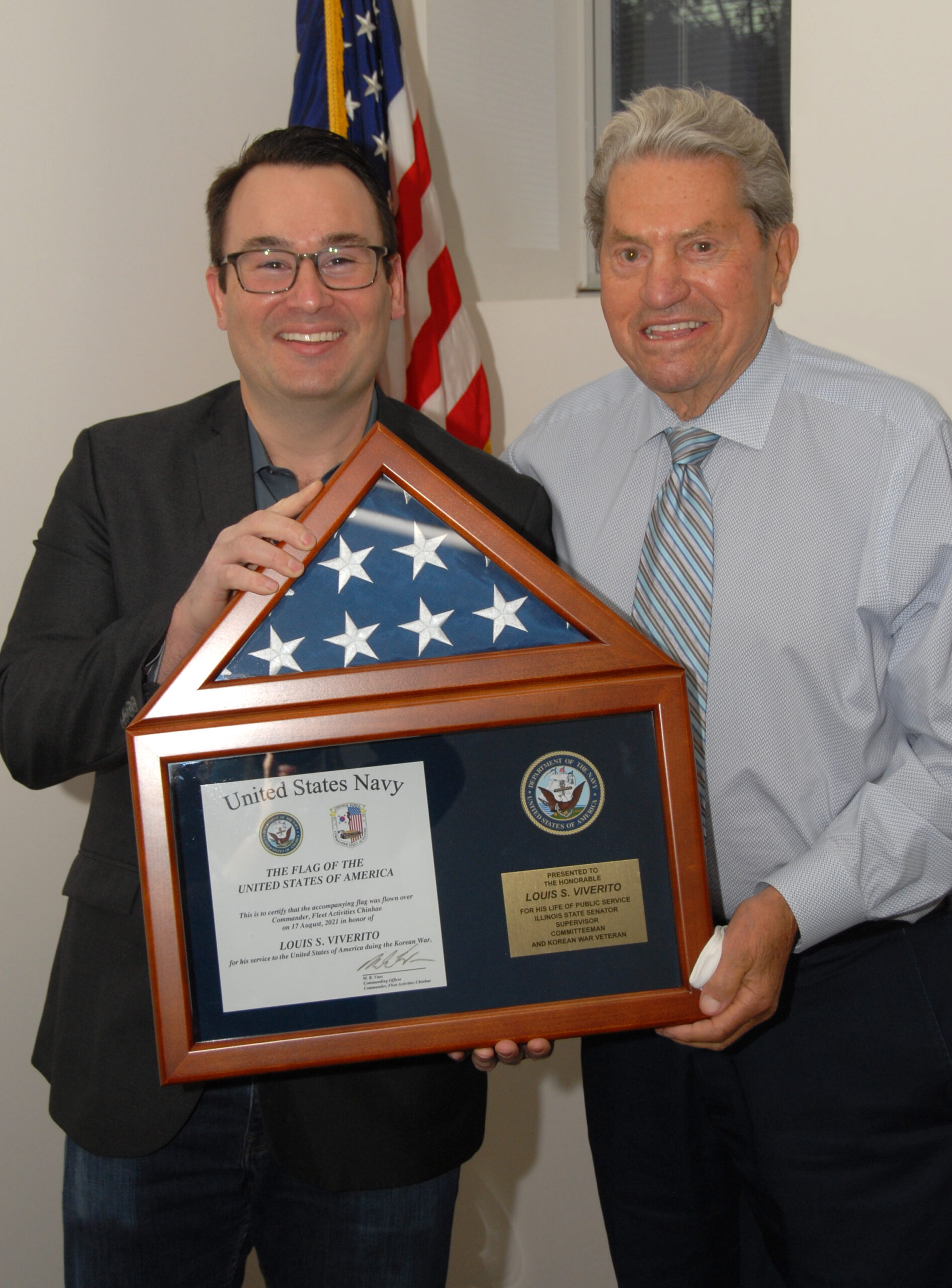 Mike Porfirio presenting a Flag flown at a military base in South Korea on behalf of Stickney Township Supervisor Lou Viverito, who served during the Korean War . Porfirio had the flag flown when he was in South Korea on Reserve orders last year. And he presented it to Viverito as a salute to his military service.